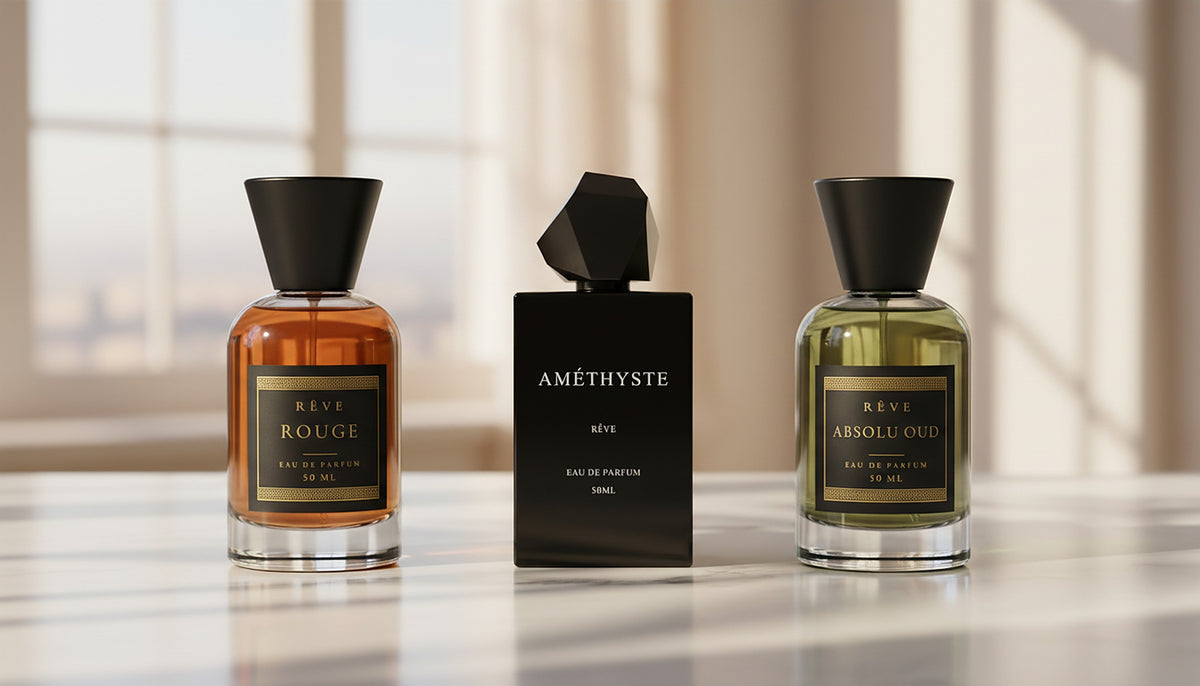 ROUGE, AMÉTHYSTE and ABSOLU OUD by RÊVE on a sunlit marble table