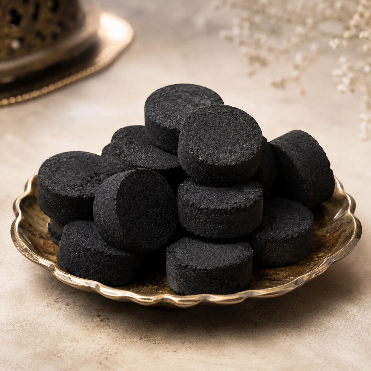 Vetiver Bakhoor — black Arabian incense discs on a brass plate by OUD REVE